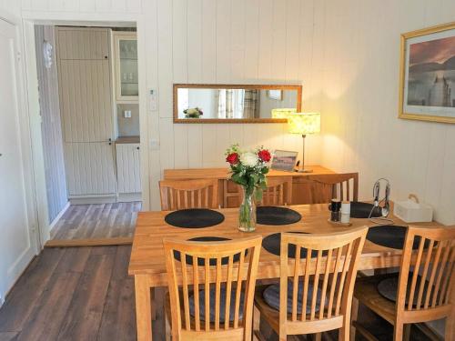 a dining room table with chairs and a vase of flowers at 5 person holiday home in SÖLVESBORG-By Traum in Sölvesborg
