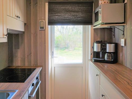 a kitchen with a microwave and a window in it at 5 person holiday home in SÖLVESBORG-By Traum in Sölvesborg