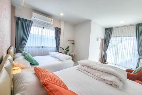 a hotel room with two beds and a window at Beloved Bliss Pool Villa Bangsaen in Chon Buri
