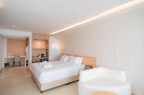 a hotel room with a bed and a chair at G9 HOTEL Kanchanaburi in Ban Tukkata (1)