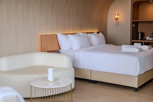 a hotel room with two beds and a table at G9 HOTEL Kanchanaburi in Ban Tukkata (1)
