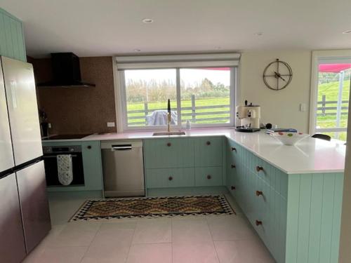 a kitchen with blue cabinets and a counter top at Rose Cottage in Puketapu