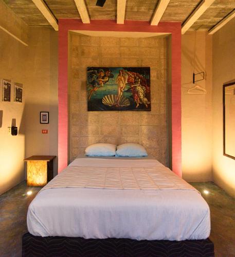 a bedroom with a bed with a painting on the wall at Habitación frente al mar y alberca in Lerma