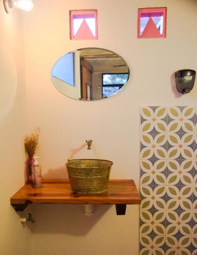 a bathroom with a mirror and a basket on a wooden shelf at Habitación frente al mar y alberca in Lerma