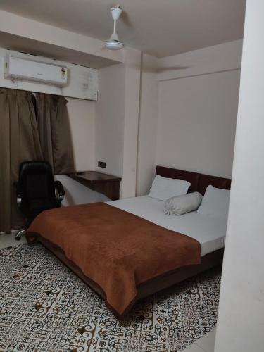 a bedroom with a bed and a chair in it at TEN Hotel in Vapi