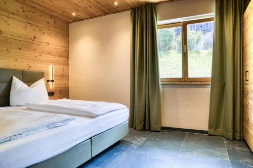 a bedroom with a bed and a window at Gästehaus Alpina in Krün