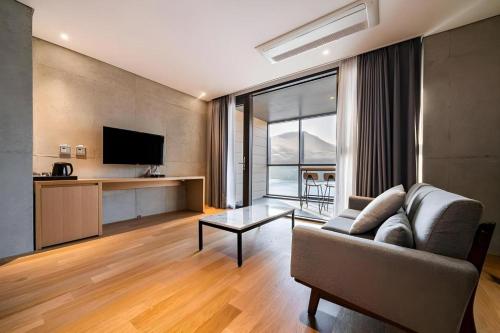 a living room with a couch and a television at Hotel Haus in Gapyeong