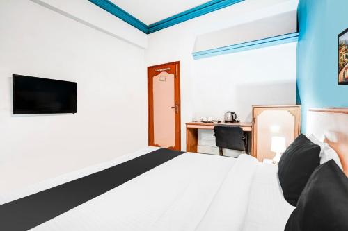 a bedroom with a bed and a desk at Super Hotel O Jamalpur Ahmedabad Formerly Hotel Peace in Ahmedabad