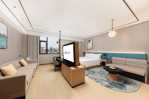 a hotel room with a bed and a flat screen tv at Hilton Garden Inn Shanghai Jiading in Shanghai