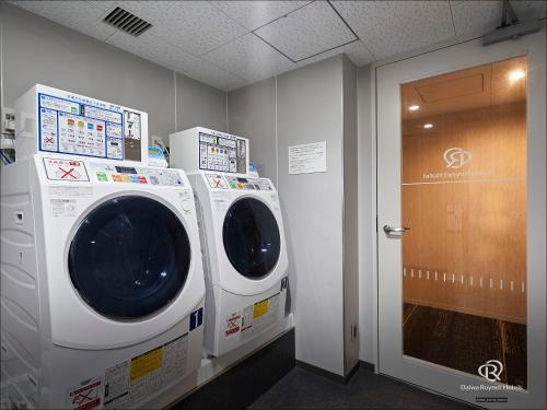 a washer and dryer in a room with a door at Daiwa Roynet Hotel Oita in Oita
