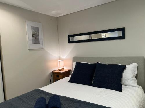 a bedroom with a bed with two blue pillows at Authur's 2 bedrooms apartment, balcony, wifi, parking, cot, sunny, washing machine drier in Auckland