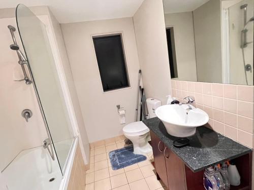 a bathroom with a sink and a toilet and a shower at Authur's 2 bedrooms apartment, balcony, wifi, parking, cot, sunny, washing machine drier in Auckland