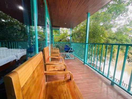 a porch with several wooden benches on a balcony at Green Bamboo Lodge Resort in Cat Tien