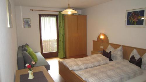 ein Wohnzimmer mit einem Bett und einem Sofa in der Unterkunft Ferienhaus-Grünfelder in Lüsen