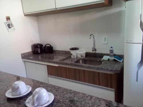 uma cozinha com um lavatório e dois pratos no balcão em Park L'acqua di roma - Cozinha completa em Caldas Novas