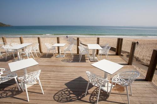 a row of tables and chairs on the beach at Carbis Bay and Spa Hotel in St Ives