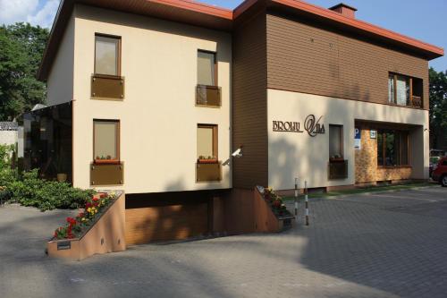 a building with a sign on the side of it at Broliu Vila in Druskininkai