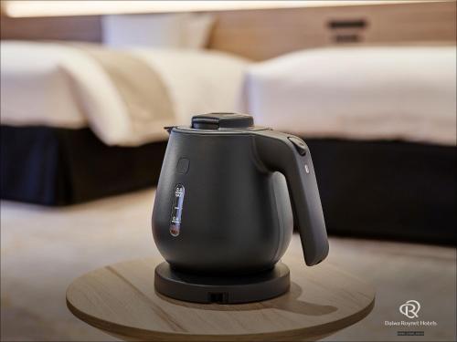 a black tea kettle sitting on a wooden table at Daiwa Roynet Hotel Oita in Oita