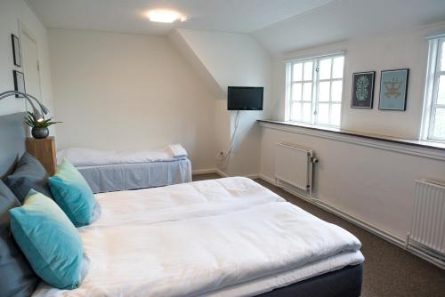 a bedroom with two beds and two windows at Refborg Hotel in Billund