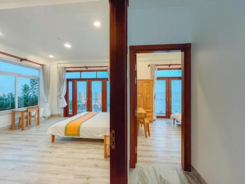a bedroom with a bed and a view of the ocean at Bay View Beach Villas Mũi Né in Ấp Khánh Phước (1)