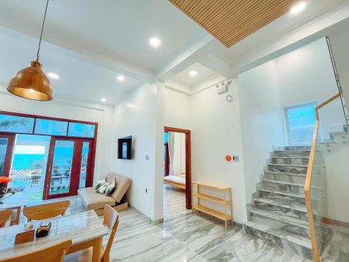 a living room with a staircase and a table at Bay View Beach Villas Mũi Né in Ấp Khánh Phước (1)