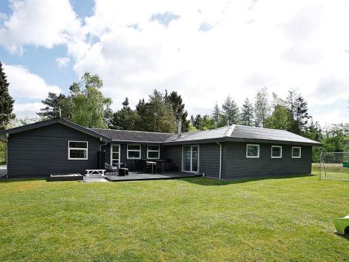 une maison noire avec une grande cour dans l'établissement Pool Paradise in Helberskov - By Traum Ferienwohnungen, à Helberskov