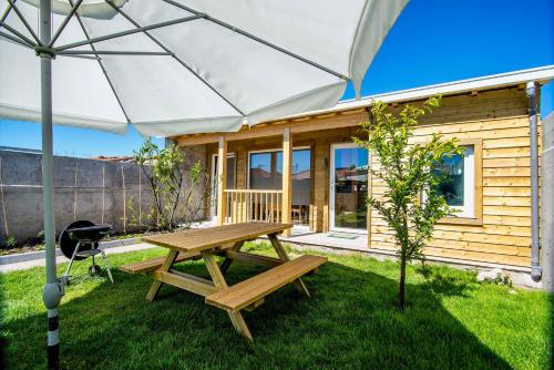 a wooden cabin with a picnic table and an umbrella at Garden House in Porto