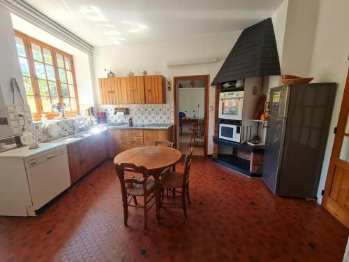 een keuken met een tafel met stoelen en een fornuis bij Holiday Home Vault-de-Lugny near Forest in Vault-de-Lugny