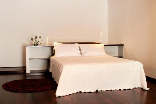 セルパにあるCasa do Caniçoのベッドルーム1室(白いシーツとテーブル付)