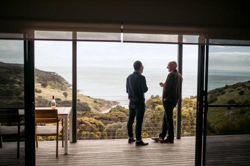 two men standing on a balcony looking out at the ocean at Sea Dragon Kangaroo Island in Penneshaw