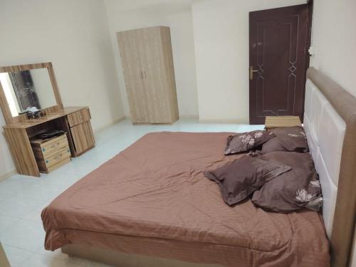 une chambre avec un grand lit et un miroir dans l'établissement شقة غرفتين وصاله وسط صلاله - Two-bedroom apartment in the center of Salalah, à Salalah