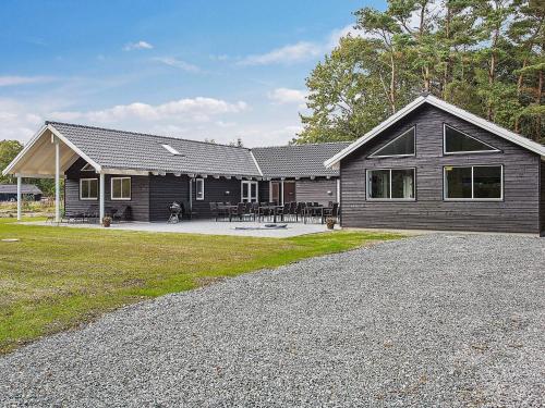 a house with a gambrel roof and a patio at Luxury Retreat with Pool - By Traum Ferienwohnungen in Stege