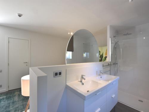 a white bathroom with a sink and a mirror at Luxury Villa in Sint-Idesbald with Jacuzzi in Sint-Idesbald