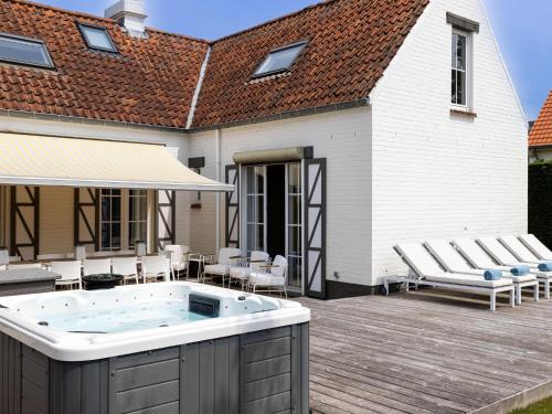 a hot tub on a deck next to a house at Luxury Villa in Sint-Idesbald with Jacuzzi in Sint-Idesbald