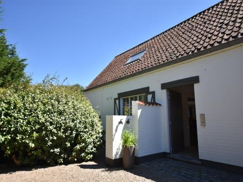 a white house with a gate and a hedge at Luxury Villa in Sint-Idesbald with Jacuzzi in Sint-Idesbald
