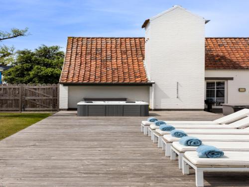 a row of chaise lounges on a wooden deck at Luxury Villa in Sint-Idesbald with Jacuzzi in Sint-Idesbald