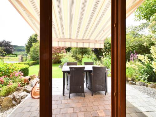a patio with a table and chairs in a yard at Beautiful Holiday Home in Durbuy with Garden in Septon