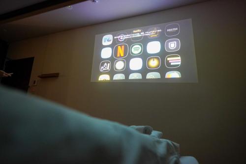 a projection screen with an iphone on a wall at COB HOTEL Asakusa in Tokyo