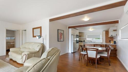 a living room with white furniture and a dining room at White Springs, Our Peaceful Holiday House In Coffin Bay in Coffin Bay