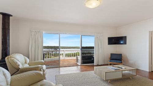 a living room with a couch and a table at White Springs, Our Peaceful Holiday House In Coffin Bay in Coffin Bay
