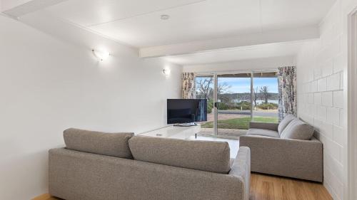 a living room with a couch and a tv at White Springs, Our Peaceful Holiday House In Coffin Bay in Coffin Bay