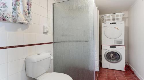 a bathroom with a toilet and a washing machine at White Springs, Our Peaceful Holiday House In Coffin Bay in Coffin Bay