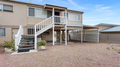 a house with a staircase in front of it at White Springs, Our Peaceful Holiday House In Coffin Bay in Coffin Bay