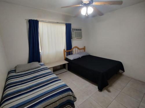 a bedroom with a bed and a ceiling fan at La Quinta Departamentos in Hermosillo