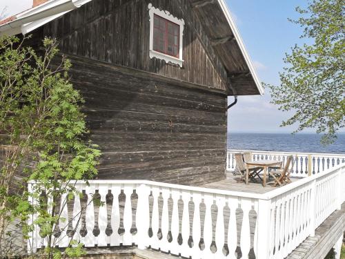 a wooden house with a balcony with a table and a window at 6 person holiday home in HOVA-By Traum in Hova