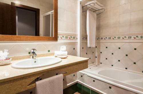 a bathroom with a sink and a tub at Hotel Doña Manuela in Daimiel