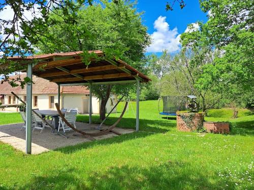 a picnic shelter with a table in a yard at Comfortable holiday home with spacious garden in Ygrande