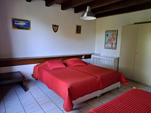 a bedroom with a red bed with red sheets at Comfortable holiday home with spacious garden in Ygrande