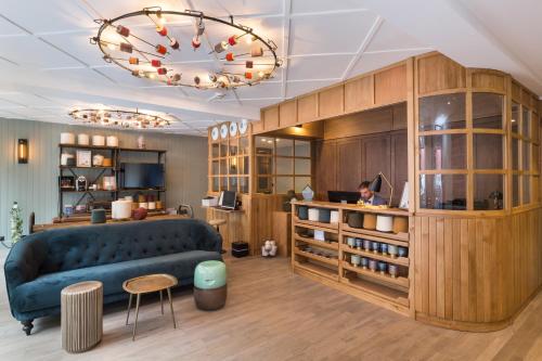 a living room with a blue couch and a desk at Hôtel Silky by HappyCulture in Lyon