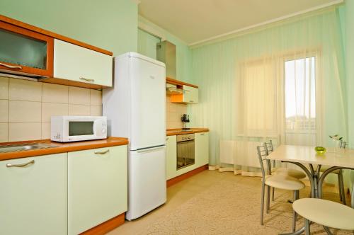 a kitchen with a white refrigerator and a table at Lukyanovsky in Kyiv